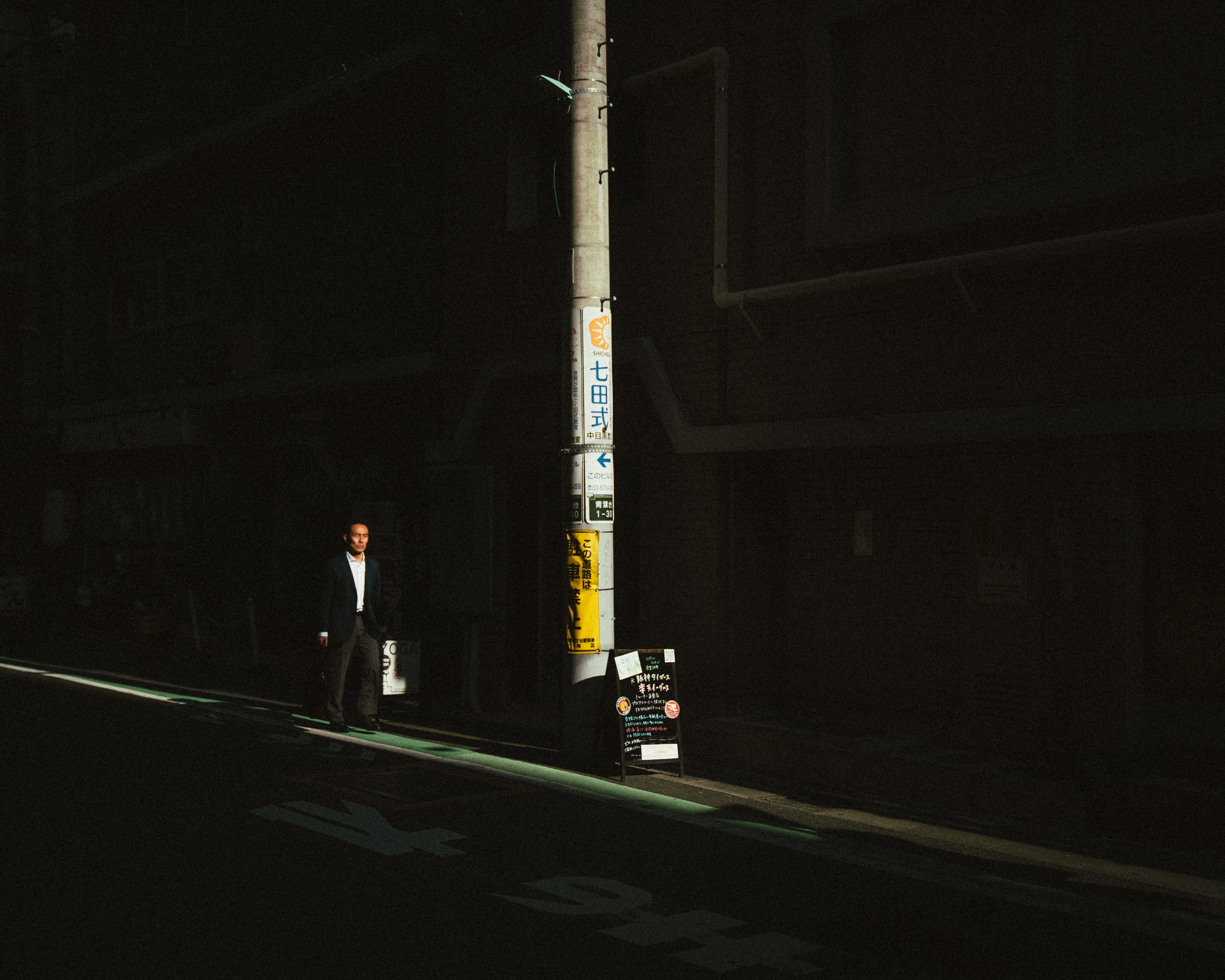 One figure, one streetlamp, an empty road.