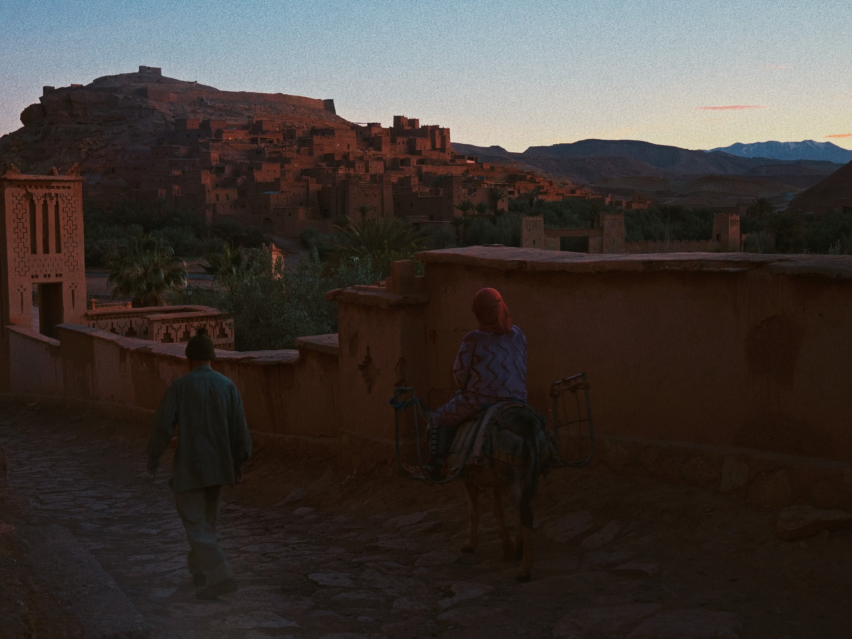 Dusk settles over the kasbah as a rider passes through.